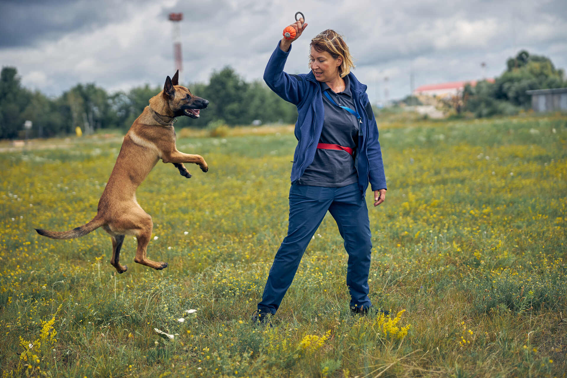 A woman training a dog outdoors